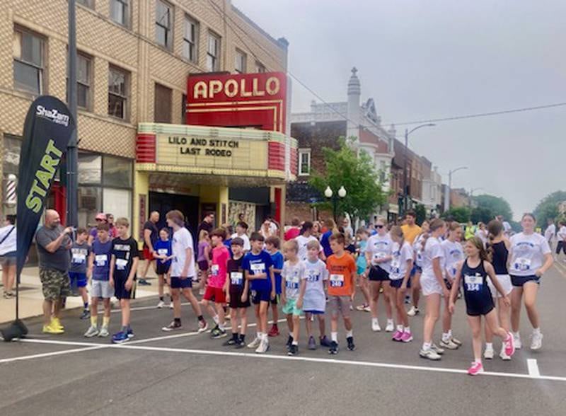 Racers line up under the landmark Apollo Theatre in downtown Princeton for the Princeton Mile Race Saturday morning. More than 100 runners came out for the inaugural race.
