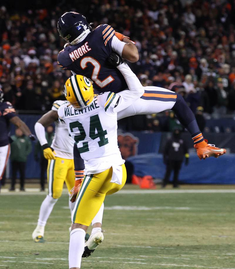 Chicago Bears wide receiver DJ Moore makes a catch in front of Green Bay Packers cornerback Carrington Valentine late in the fourth quarter Saturday, December 20, 2025, during their game at Soldier Field in Chicago.