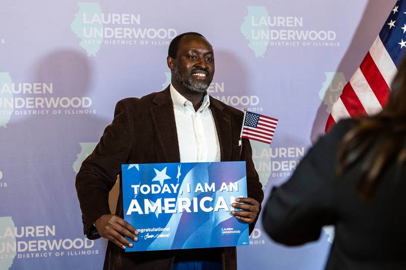 New U.S. citizen JDD Nduwayo, of Naperville, takes a photo following the Naturalization Ceremony at Rialto Square Theatre in Joliet on April 17, 2025.