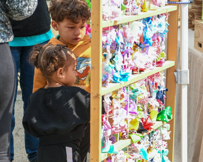 Siblings Timoth and Talia Enright of Downers Grove check out one of the booths at the Farmers Market on Saturday May 31, 2025, held at the Main Street train station in Downers Grove.