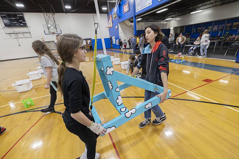 Rock Falls Middle School seventh graders Lilly Saldino (left) and Amy Finney haul their catapult off the court after finishing their round.