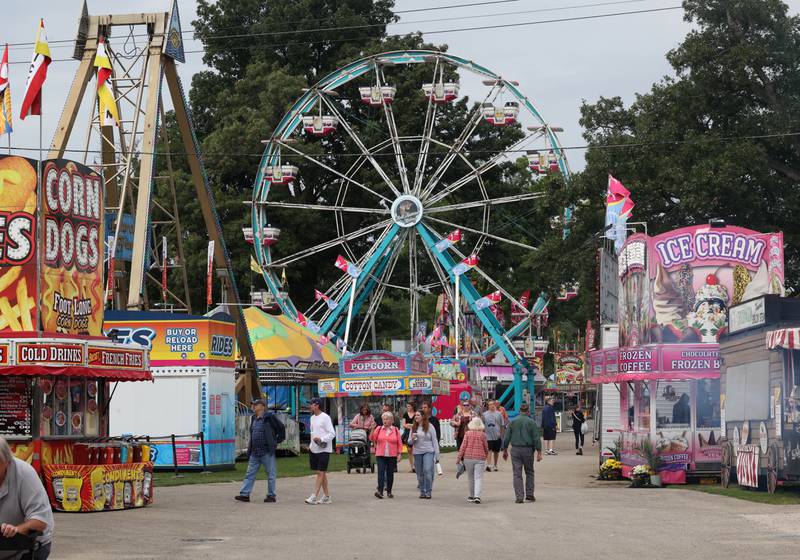 Visitors walk down one of the main pathways near the carnival rides Wednesday, Sept. 3, 2025, on opening day of the Sandwich Fair.