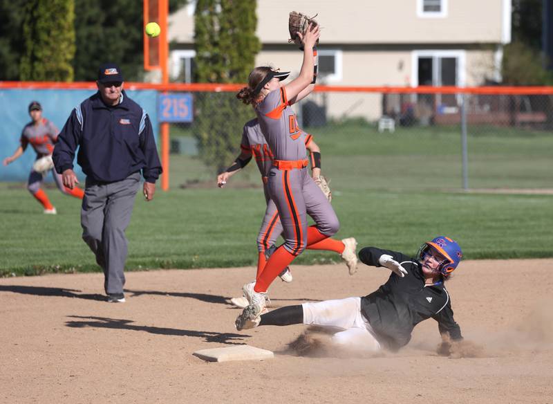 Genoa-Kingston's Olivia Vasak slides in under a leaping DeKalb's Hazel Montavon for a stolen base Thursday, May 8, 2025, during their game at Genoa-Kingston High School.