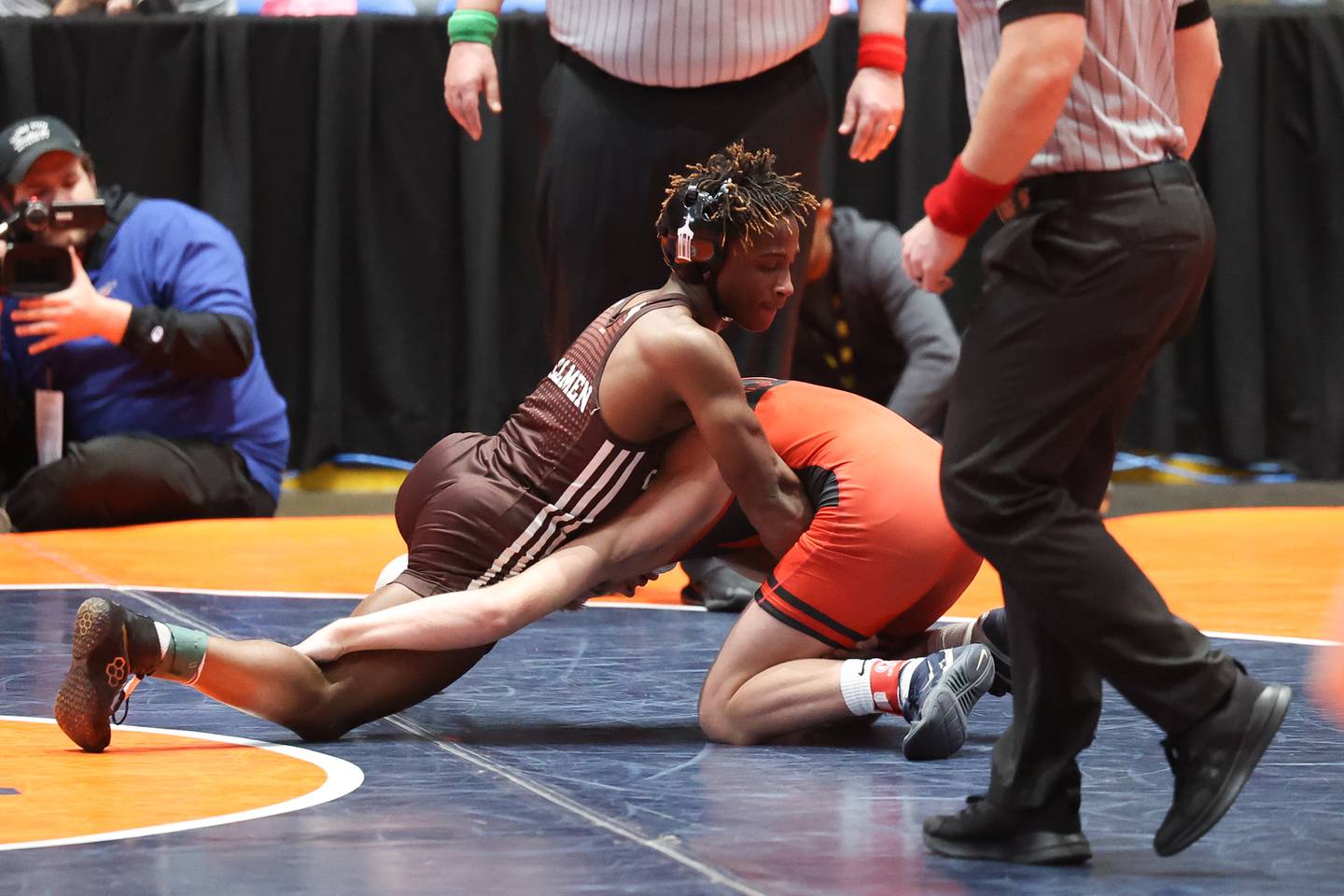 Joliet Catholic’s Gylonn Sims (left) works over Washington’s Wyatt Medlin in the 132-pound match Saturday, Feb. 25, 2023, at Grossinger Motors Arena in Bloomington.