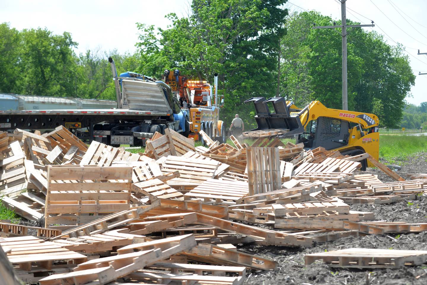 A worker with Maggio Truck Center, Rockford, uses a skid-steer to collect pallets that spilled from a semi-tractor and trailer on Pines Road Thursday afternoon. The accident forced the closure of a portion of Pines Road from the city limits, west to Gale Road, for several hours. The truck was hauling wooden pallets that were scattered in the north ditch. The accident remains under investigation.