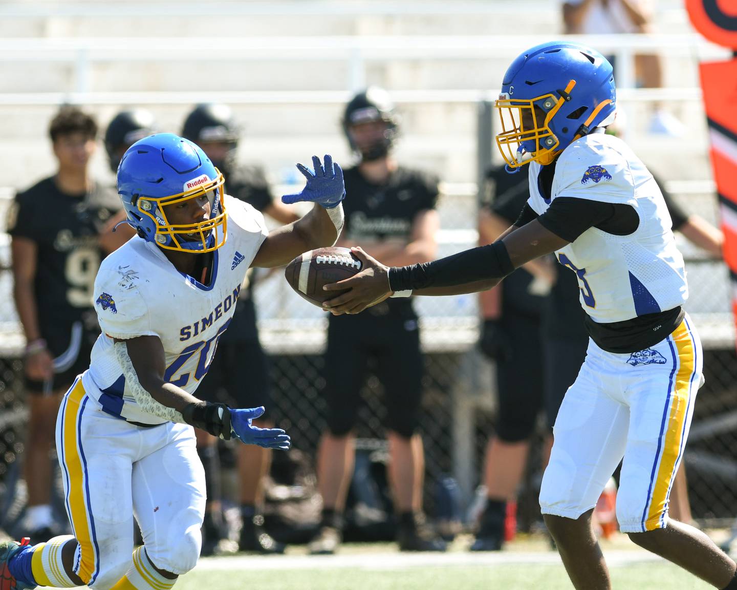 Simeon QB Keshawn Parker, right, hands the ball to running back teammate Te’shon McGee during the first quarter while taking on Simeon on Saturday Sep. 2, 2023, at Gately Stadium in Chicago.