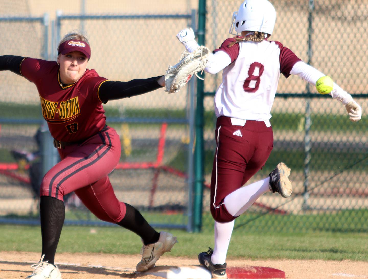 Marengo’s Gabrielle Geiseke is safe at first as Richmond-Burton’s Chase Cooper, left, looks for the wide throw  in varsity softball on Tuesday, April 22, 2025, at Marengo High School in Marengo.