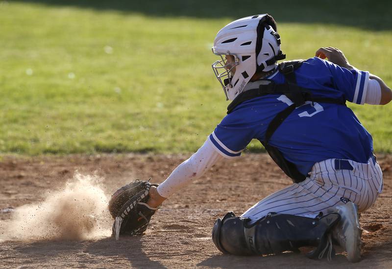Woodstock’s  Trevor Cote digs the ball out of the dirt during a Kishwaukee River Conference baseball game against Woodstock North Tuesday, April 18, 2023, at Emricson Park.