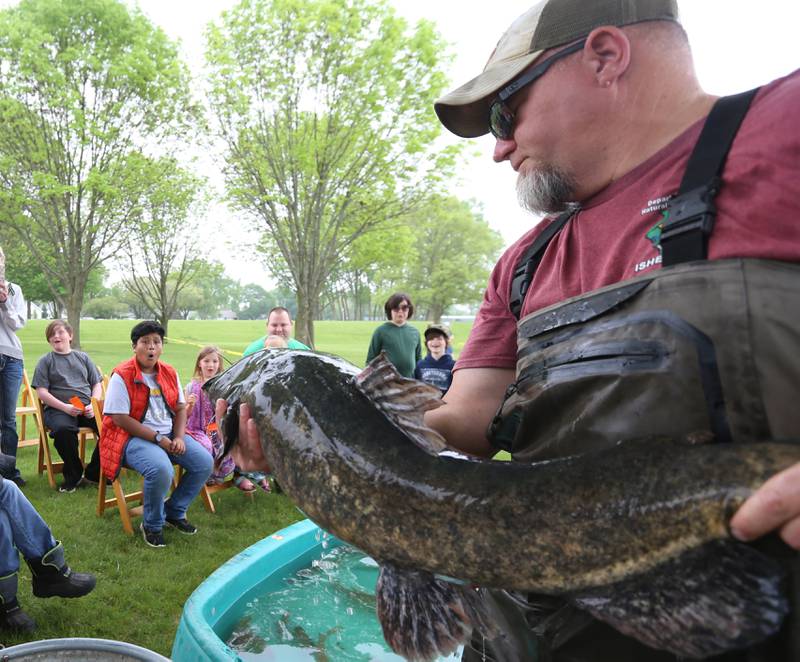 David Wyffels a fish biologist with the Illinois Department of Natural Resources holds a large flathead catfish taken from the Hennepin Canal during the twenty-third annual Kids Fishing Expo on Saturday, May 13, 2023 at Baker Lake in Peru.
