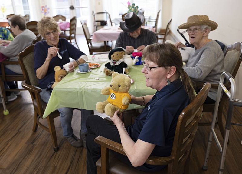Heritage Woods employee Jennifer Vock shows off her husband’s memorial bear Friday, March 31, 2023 during the party.