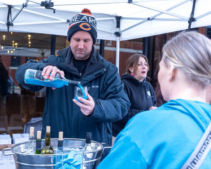 Man pours wine into glass at the wine walk on Feb. 14, 2026 on Mill Street in Utica.