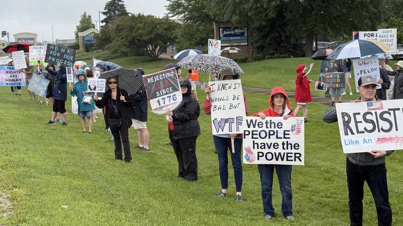 Participants at the "Together for Justice" rally, organized by We Can Lead Change Fox Valley hold signs in protest on South Randall Road near Gleneagle Drive in Geneva on Saturday, July 19, 2025.