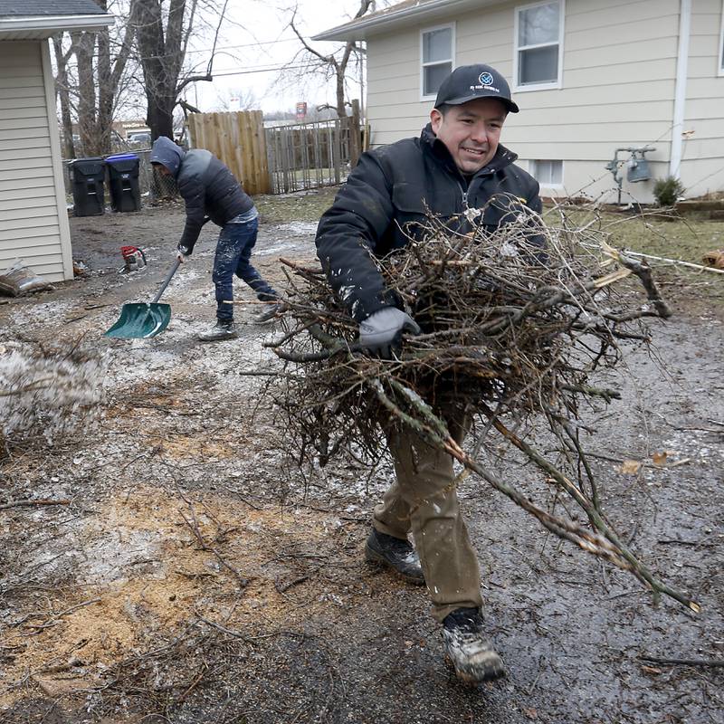 Rodolfo Lopez and his brother Arturo Lopez clean up Rodolfo Lopez’s yard Thursday, Feb. 23, 2023, in the 4900 block of State Street in Crystal Lake, after cutting up tree branches that came down in the ice storm. McHenry County residents recovered Thursday from a winter storm that knocked down trees and caused power outages throughout the county.