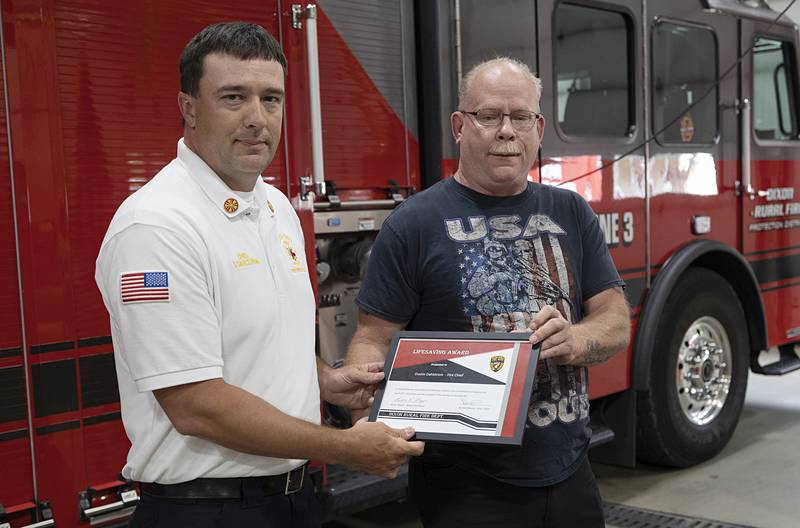 Robert Schiefelbein (right) presents Dixon Rural Fire Chief Dustin Dahlstrom with the department's Lifesaving Award on Tuesday, June 11, 2024.