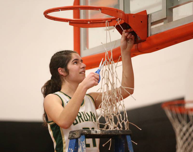 St. Bede's Lily Bosnich smiles while cutting down a piece of the net after defeating Serena in the Class 1A Sectional final game on Thursday, Feb. 22, 2024 at Gardner-South Wilmington High School.