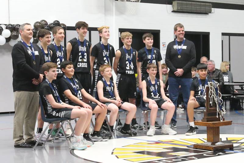 Members of the Mendota Holy Cross eighth-grade boys basketball team pose with the Class 1A State chamipionship trophy during a reception on Tuesday, Feb. 20, 2024 at Holy Cross School. The team beat Pana Sacred Heart 41-33 to win the IESA Class 1A State championship.
