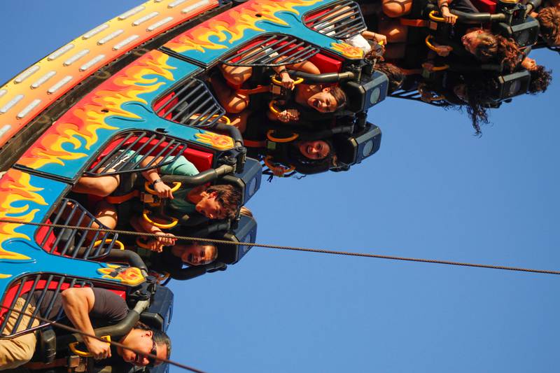 Attendees of the Downers Grove Rotary GroveFest laugh while riding the "Ring of Fire" ride, on Thursday, June 19, 2025.
