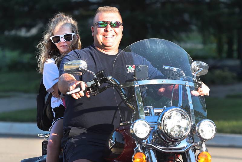 Lily Lippold arrives in style for her first day of fourth grade on the back of her dad Neal's motorcycle Tuesday, Aug. 16, 2022, on opening day at Genoa Elementary School.