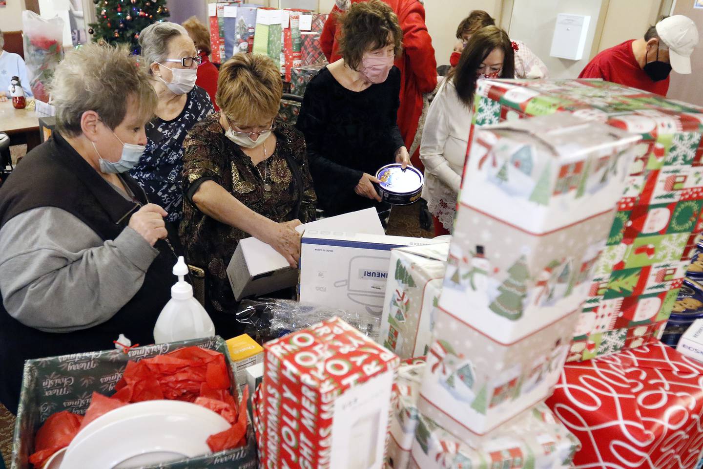 Residents look through a table piled high with gifts during an adopt-a-grandparent gift event at Gable Point Senior Housing on Wednesday, Dec. 22, 2021, in Crystal Lake.