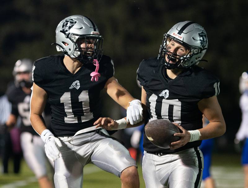 Kaneland’s Dominick DeBlasio (11) and Troyer Carlson (10) celebrate a touchdown against Riverside Brookfield during a 6A playoff football game at Kaneland High School in Maple Park on Friday, Oct 28, 2022.