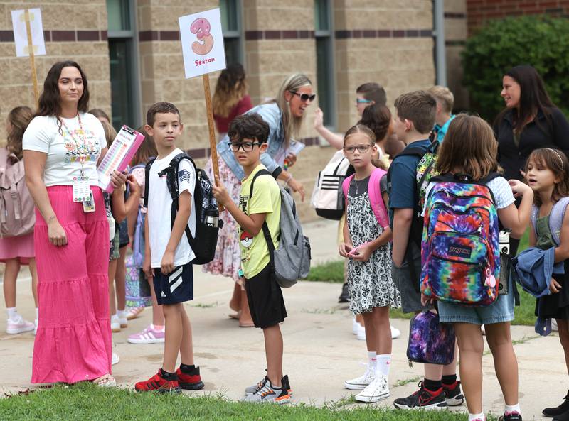 Third graders line up with their new classmates Thursday, Aug. 21, 2025, as they arrive for the first day of school at North Grove Elementary School in Sycamore.