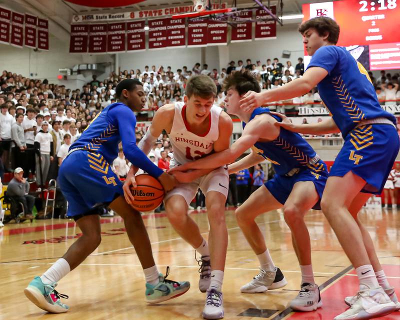Lyons Caleb Greer (3) grabs at the ball from Hinsdale Central's Ben Oosterbaan (12) during varsity basketball game between Lyons at Hinsdale Central.  Jan 20, 2023.