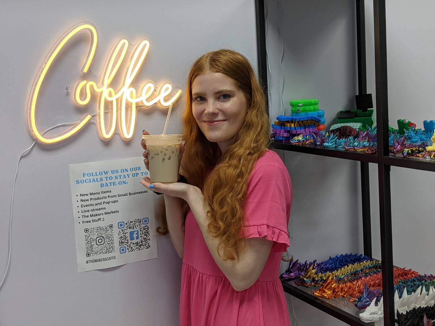 Sierra Moore, owner of Roots Coffee Stand, holds one of the drinks for sale at The Makers Cafe and Markets in Oswego.