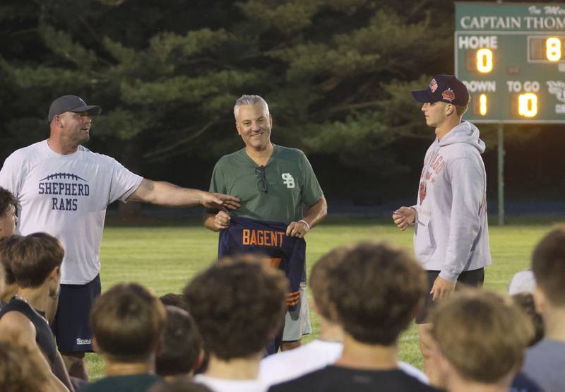 Travis Bagent (left) and his son Chicago Bears quarterback Tyson Bagent (right) present a autographed jersey to St. Bede alumni Kevin Micheli during the Tyson Bagent Offensive Skills Camp on Saturday, May 23, 2026 at St Bede Academy. Micheli helped bring Bagent's camp to St. Bede.