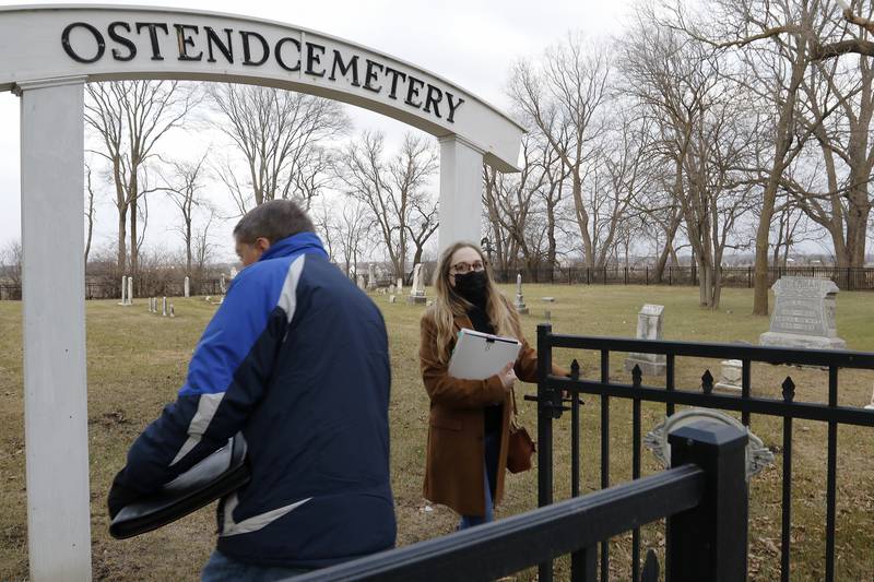 Amanda Helma and Doug Peterson, both of the McHenry area, search through Ostend Cemetery to find an unmarked burial plot on Tuesday, Dec. 21, 2021, in McHenry. The two are working to identify the boy who died in 1963 and issue a headstone for him.