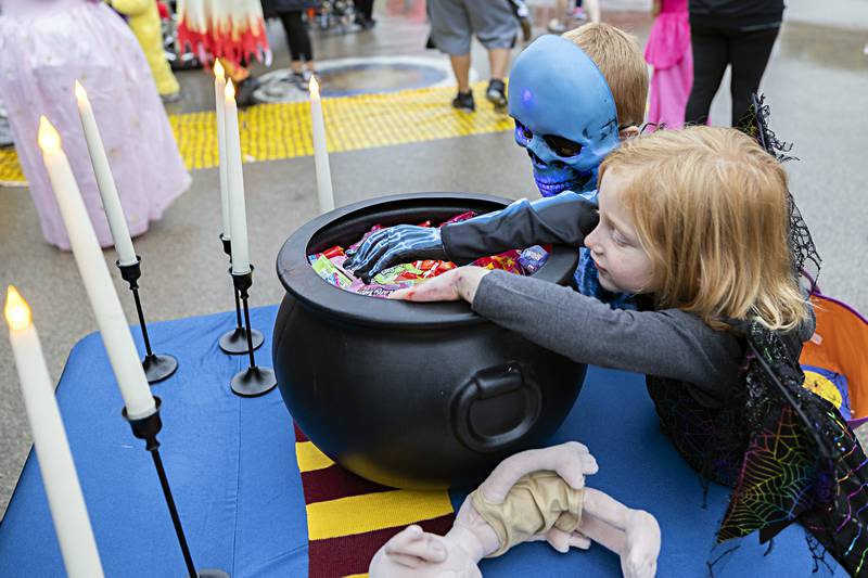 Ryder Roe (left), 6, and Robyn Roe, 4, dig into some candy from the Dixon Police Department booth Wednesday, Oct. 25, 2023 at Washington School.