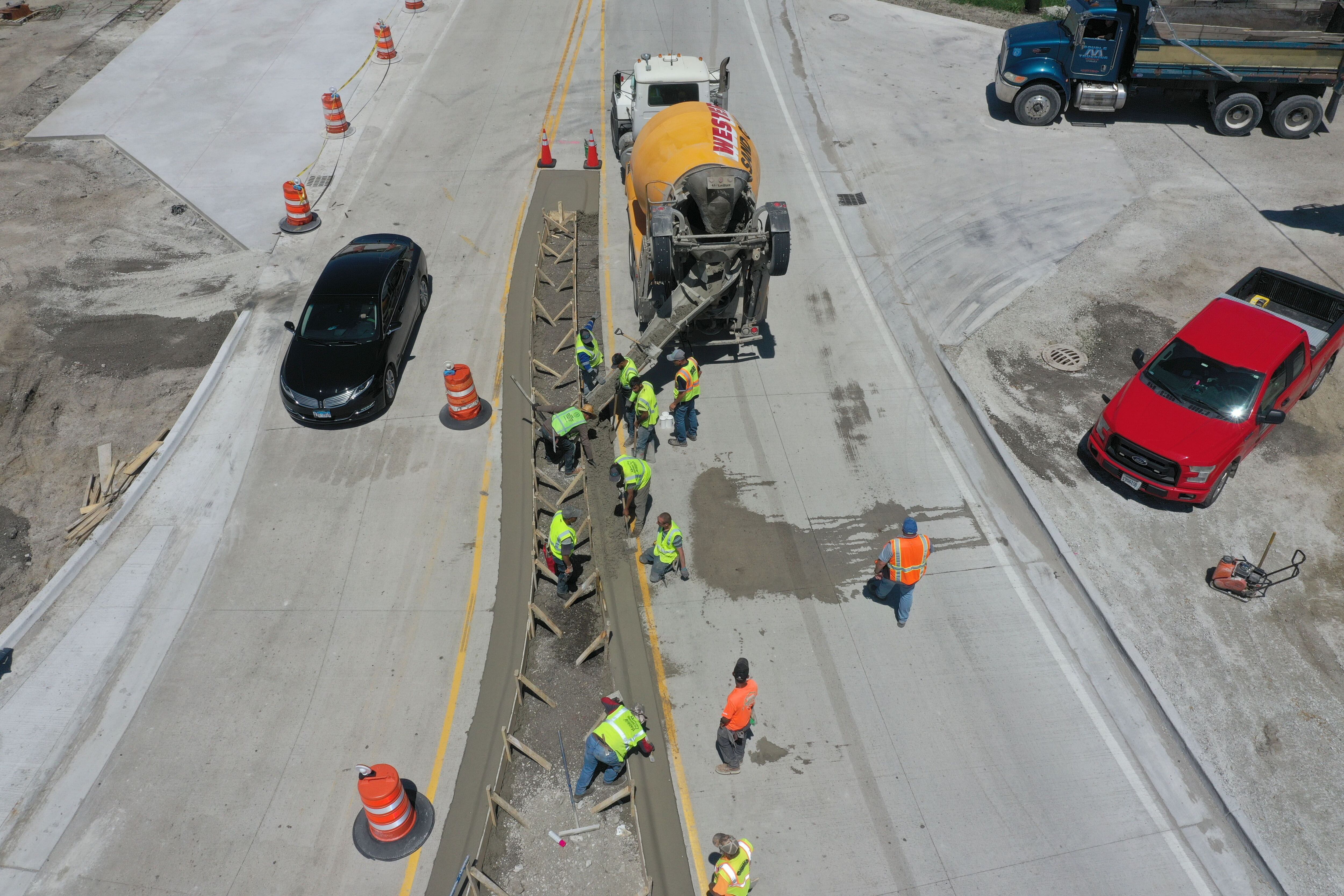 Crews pour concrete on the northern approach to the roundabout on Tuesday, May 16, 2023, at the intersection of Route 178 and U.S. 6 in Utica.