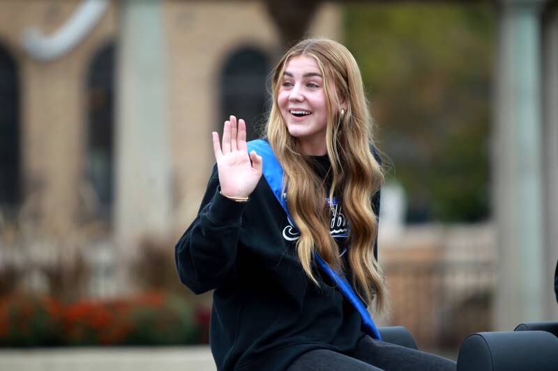 St. Charles North softball player Haley Nelson waves from the top of a convertible during the school’s annual homecoming parade on Main Street through downtown St. Charles on Thursday, Oct. 19, 2023.
