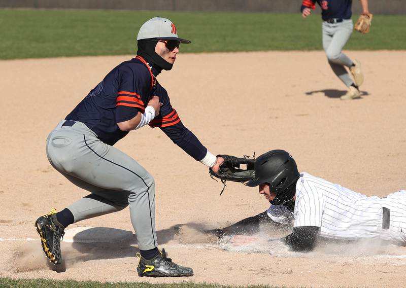 DeKalb's Matthew Clayton slides back to third safely as Naperville North's Brady Marino waits for the throw Tuesday, April 15, 2025, during their game at DeKalb High School.