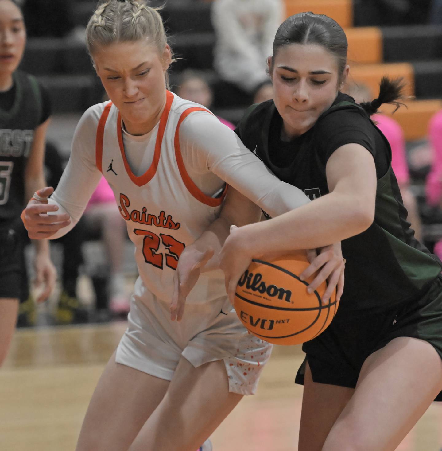 St. Charles East’s Alyse Price and Glenbard West’s Ellie Noble, right, fight for the ball in a girls basketball game in St. Charles on Tuesday, Jan. 28, 2025.