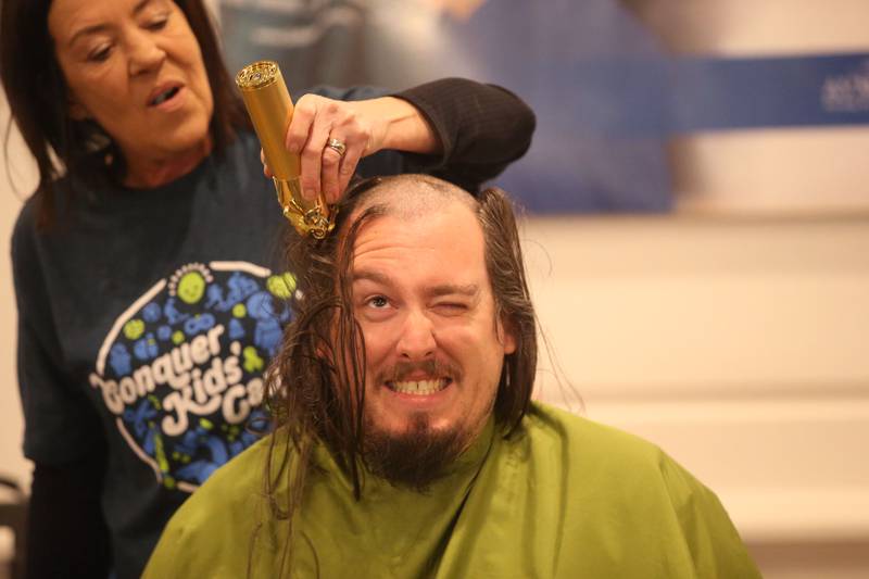 Travis Crum, has his head shaved by beautician Jennifer Stoneking, owner of Utica Hair Company, during the 18th annual Illinois Valley Emergency Services St. Baldrick's event on Sunday, March 23, 2025 at Senicas Oak Ridge in La Salle. Crum also donated his h