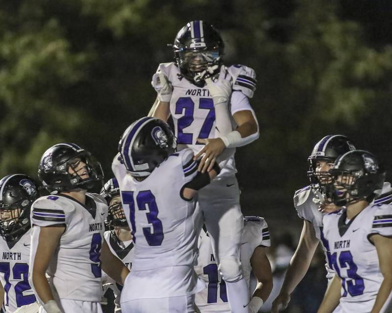 Downers Grove North's Kevin Jay Jr. (27) celebrates a touchdown run with Colin Murphy (73) during football game between Downers Grove North at Downers Grove South Friday, Sept 5, 2025  in Downers Grove.