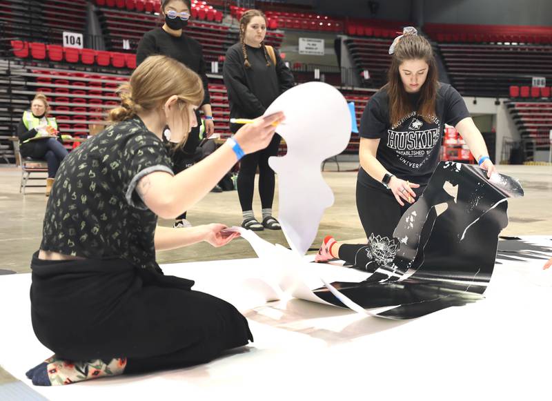 Northern Illinois University photography students remove the design template for the giant paper snowflake they are making Tuesday, March 29, 2022, in the Convocation Center at NIU in DeKalb. The students are attempting to break the world record for the largest paper snowflake.