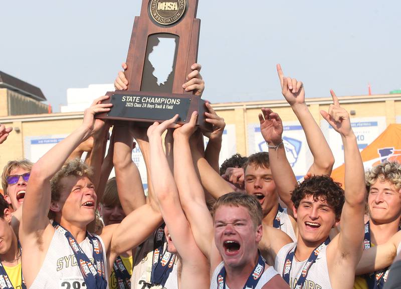 Members of the Sycamore boys  track team hoist the Class 2A first place trophy during the IHSA Class 1A Boys Track & Field State Finals on Saturday, May 31, 2025 at Eastern Illinois University in Charleston.