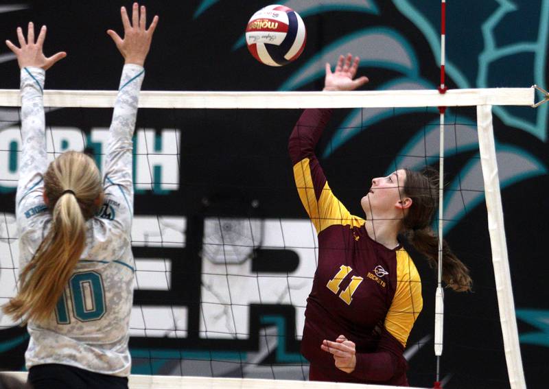 Richmond-Burton’s Maggie Uhwat, right, sends the ball over the net in varsity volleyball at Woodstock Monday night.