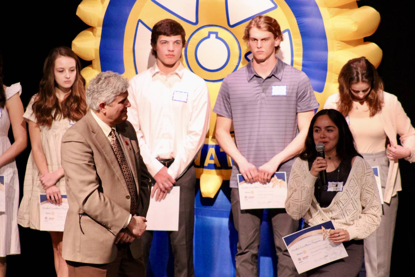 Sauk Valley Community College President Dave Hellmich, in his role as president of the Sterling Noon Rotary Club, listens as Sterling High School student Sarah Navarro lists her post-graduate plans on Wednesday during the 37th Sterling Noon Rotary Student Excellence Program held at Centennial Auditorium.