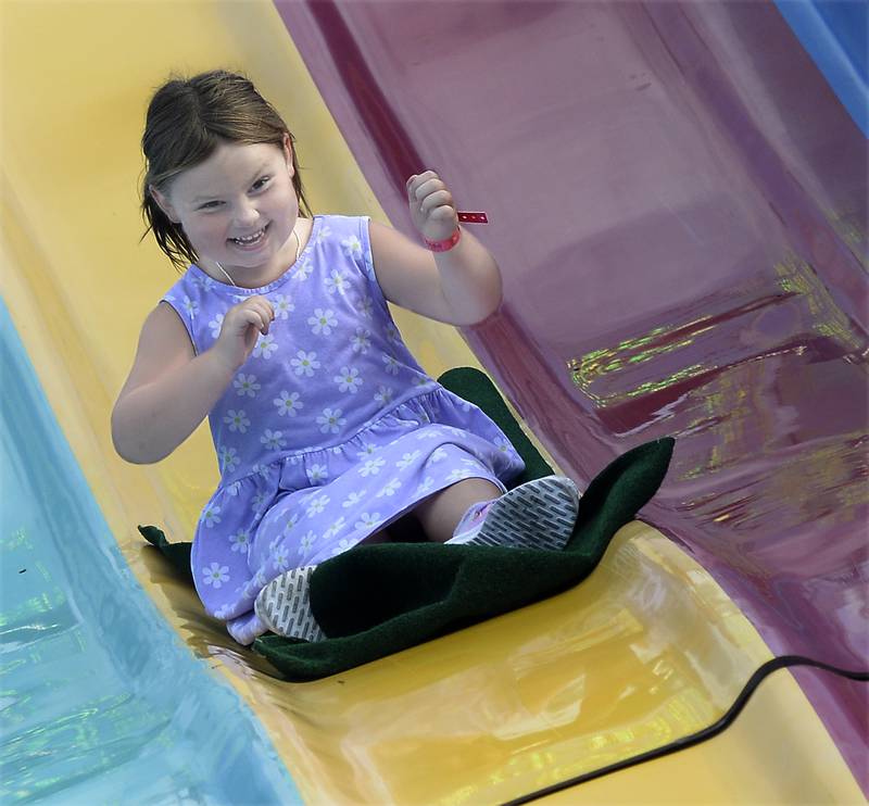 Jessica Fetter is all smiles Thursday, Aug. 3, 2023, as she goes down the Fun Slide during the opening night of the Streator Fest carnival at Northpoint Plaza.