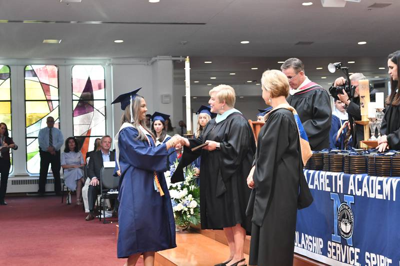 Aliyah Alikhan is the first member of her class to receive a diploma from Principal Therese Hawkins and President Deborah Tracy during Nazareth Academy’s commencement ceremony in La Grange Park on Sunday, May 21, 2023.