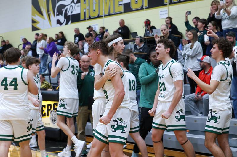 Bishop McNamara's Coen Demack, center, and Karter Krutsinger (23) celebrate with teammates as the Fightin' Irish's secured a 66-52 victory over El Paso-Gridley in the IHSA Class 2A Herscher Regional championship on Friday, Feb. 27, 2026.