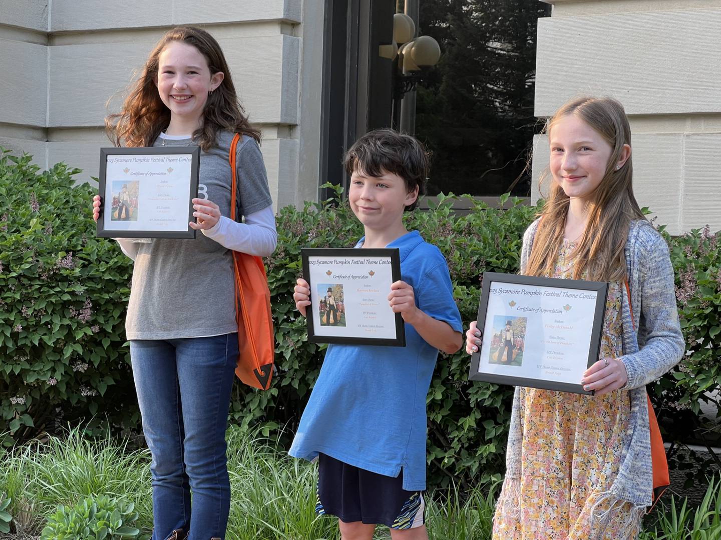 (L-R): 2023 Sycamore Pumpkin Festival theme contest runner up, Allison Vavra, a fifth grader from St. Mary's in Sycamore; contest winner Harrison Rowland of Southeast Elementary; and Finley McDonald, a fifth grader from Southeast Elementary School, pose with their certificates during a theme contest announcement for the festival Wednesday, May 17, 2023 outside the DeKalb County Courthouse, 133 W. State St., Sycamore.