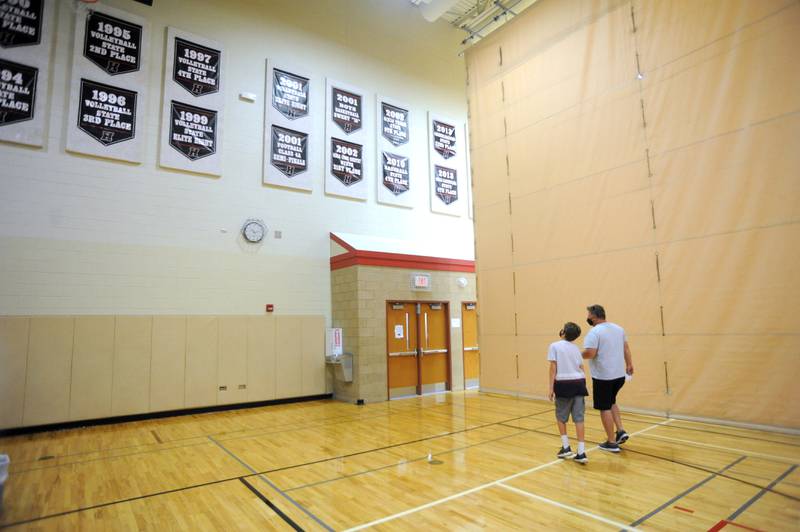 James Harden, 12, glances at the banners hanging in the gym as he and his father, Michael, walk out of the gym Saturday morning, July 31, 2021, after James received a dose of the Pfizer Covid Vaccine during a Walgreen’s Vaccination Clinic at Huntley High School.
