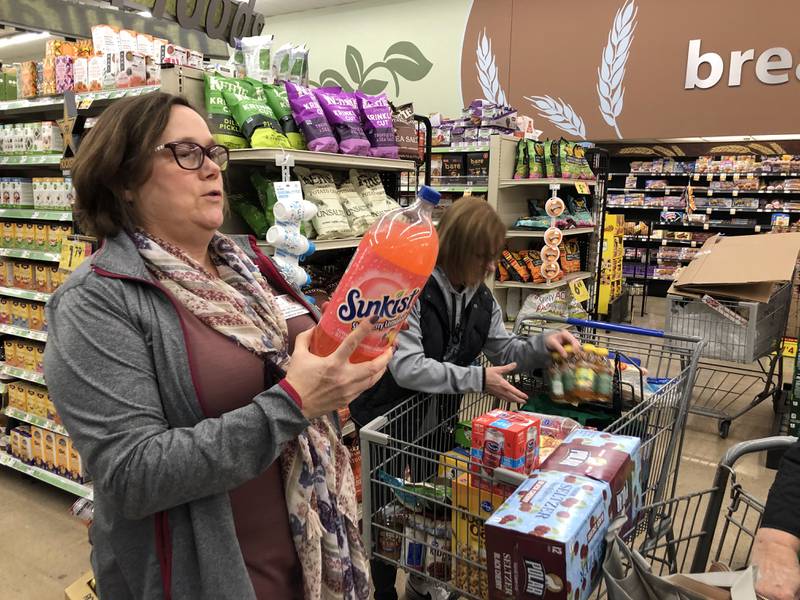 Anne Lauterjung reads aloud a soft drink label during the OSF grocery store tour at Kroger in Ottawa on Sunday, Nov. 13, 2022.