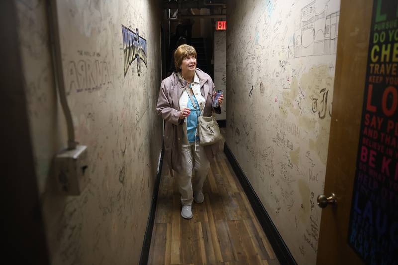 Jo Anne Vidmar looks at the hundreds of autographs of past performers back stage at the Rialto Theater’s 100th anniversary celebration on Sunday, May 3, 2026 in Joliet.