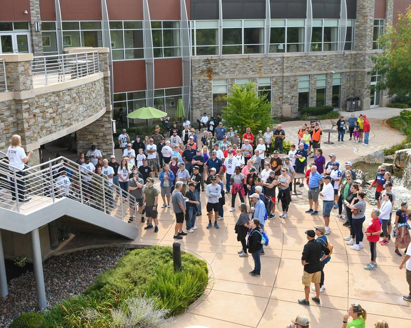 Participants listen as organizer Cindy Hupke of the DeKalb American Legion Post No. 66 talks on Sunday, Sept. 21, 2025, before the start of the second annual Be the One Walk to end veteran suicide held at Northwestern Medicine Kishwaukee Health & Wellness Center in DeKalb.