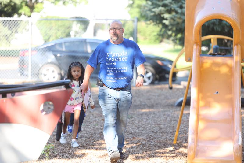 3rd grade teacher Jason Kuefler helps a student get to class on the first day of school at Woodland Elementary School in Joliet. Wednesday, Aug. 17, 2022, in Joliet.
