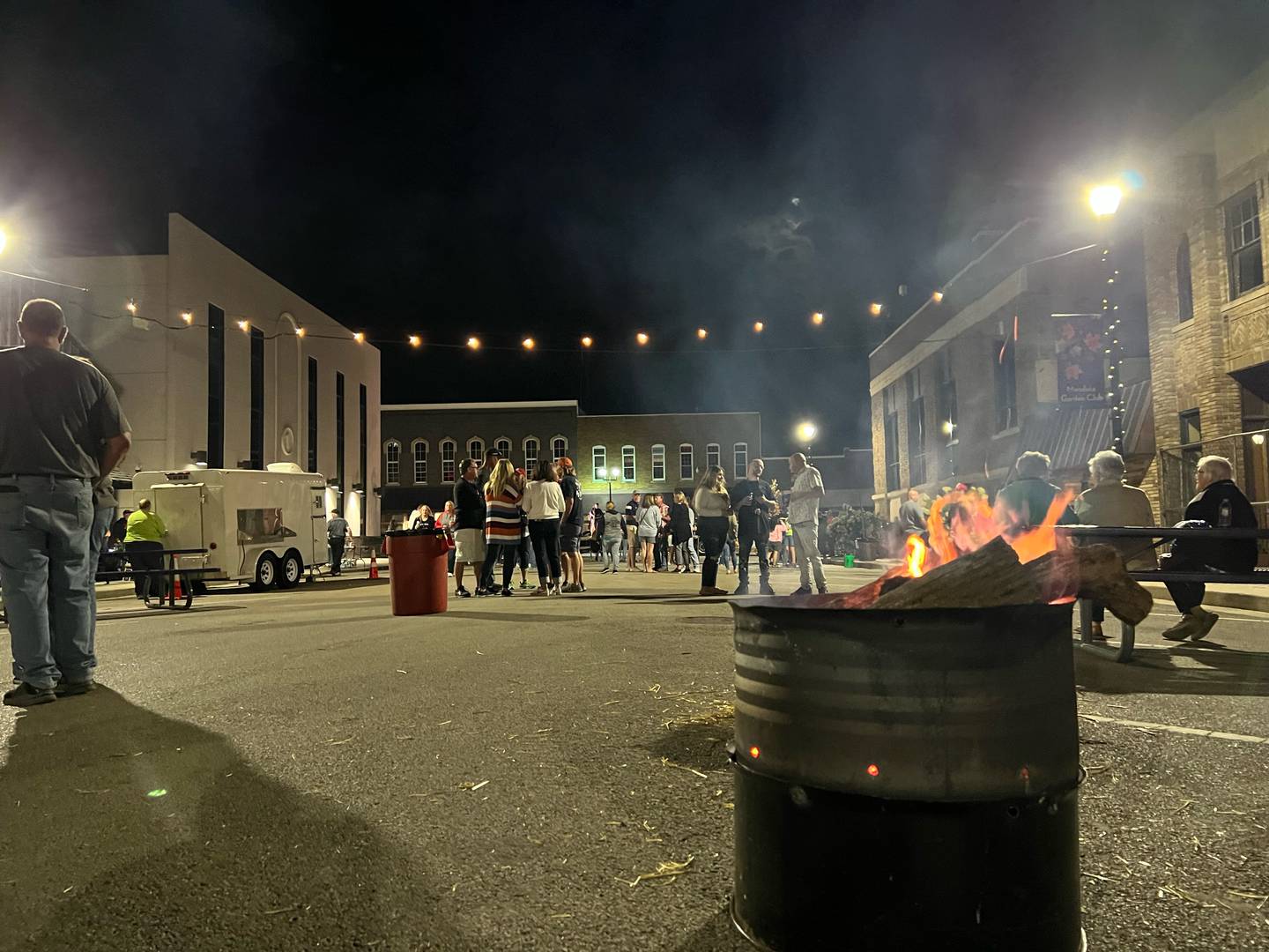 A fire keeps visitors warm during Reimagine Mendota's street party Saturday, Sept. 23, 2023, in the city's downtown.